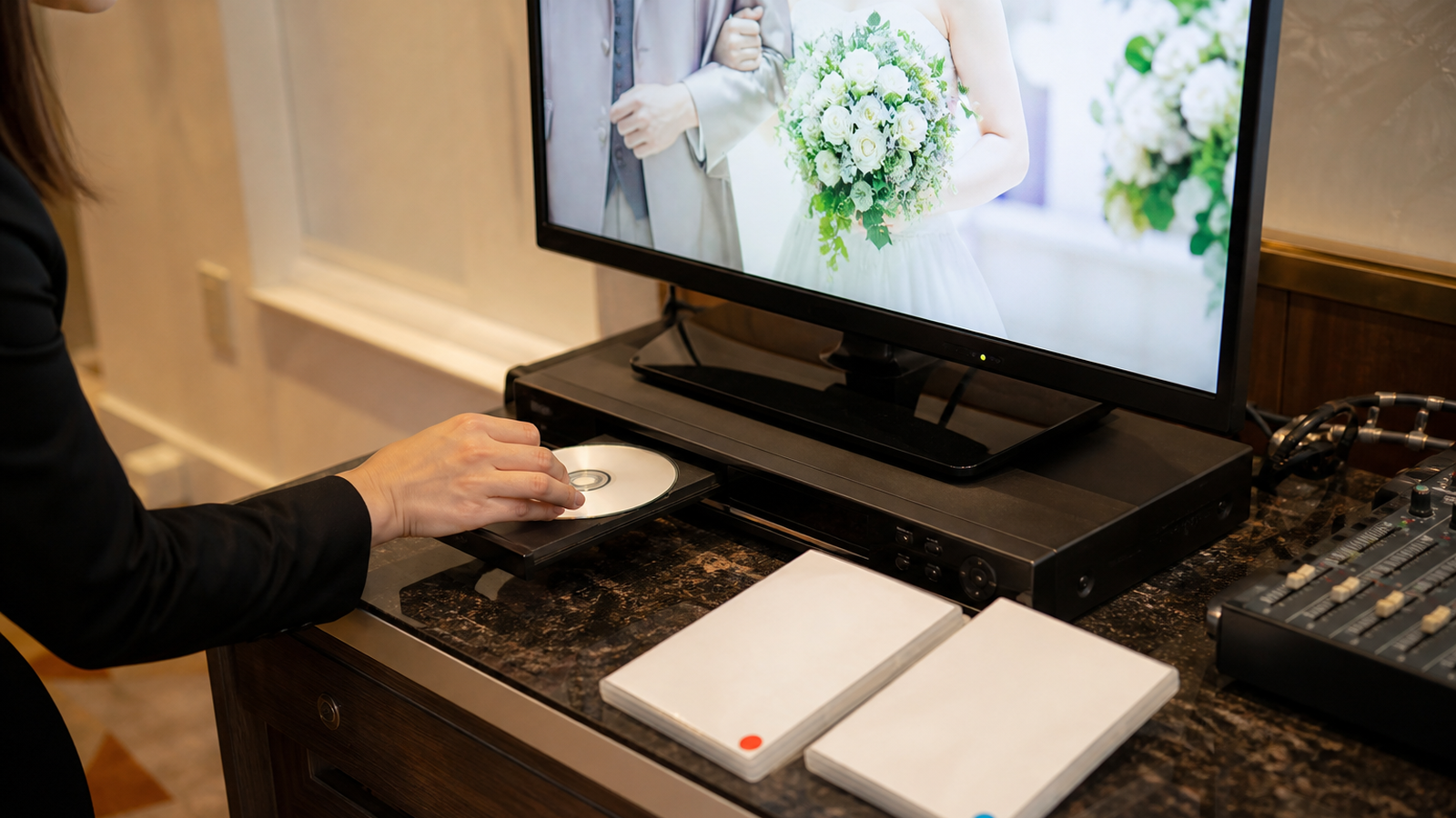結婚式DVDの本番用と予備用を会場機材で再生確認する様子